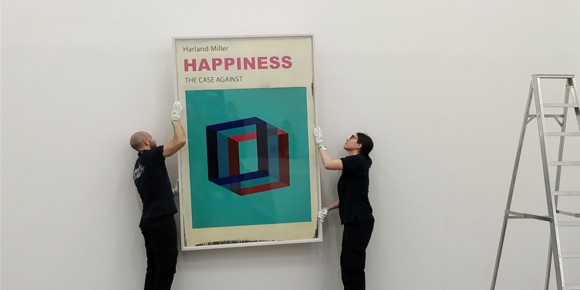 two people installing an artwork